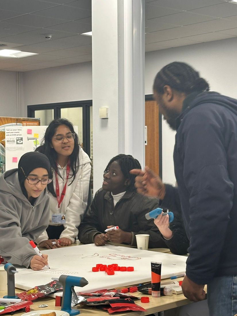 Chubby guiding students making a bottle cap artwork