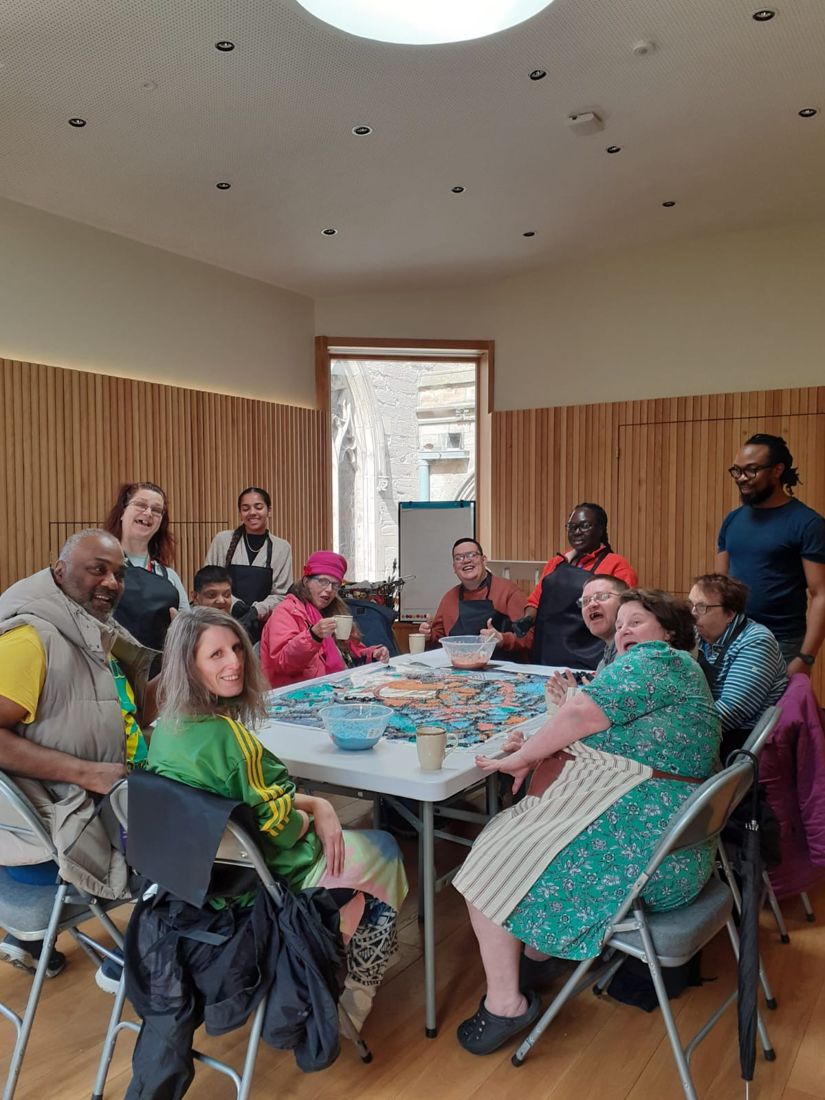 Participants around a table making the paper pulp map at Leicester Cathedral