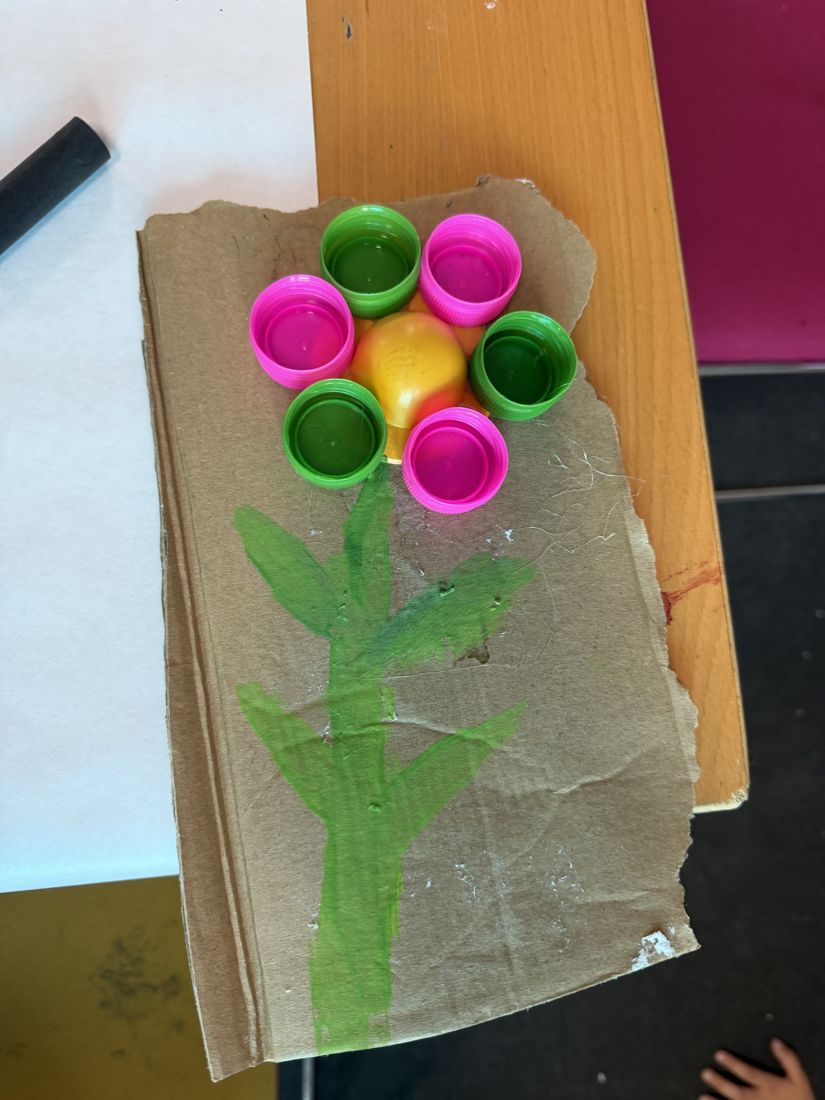 A single bottle cap flower on painted cardboard