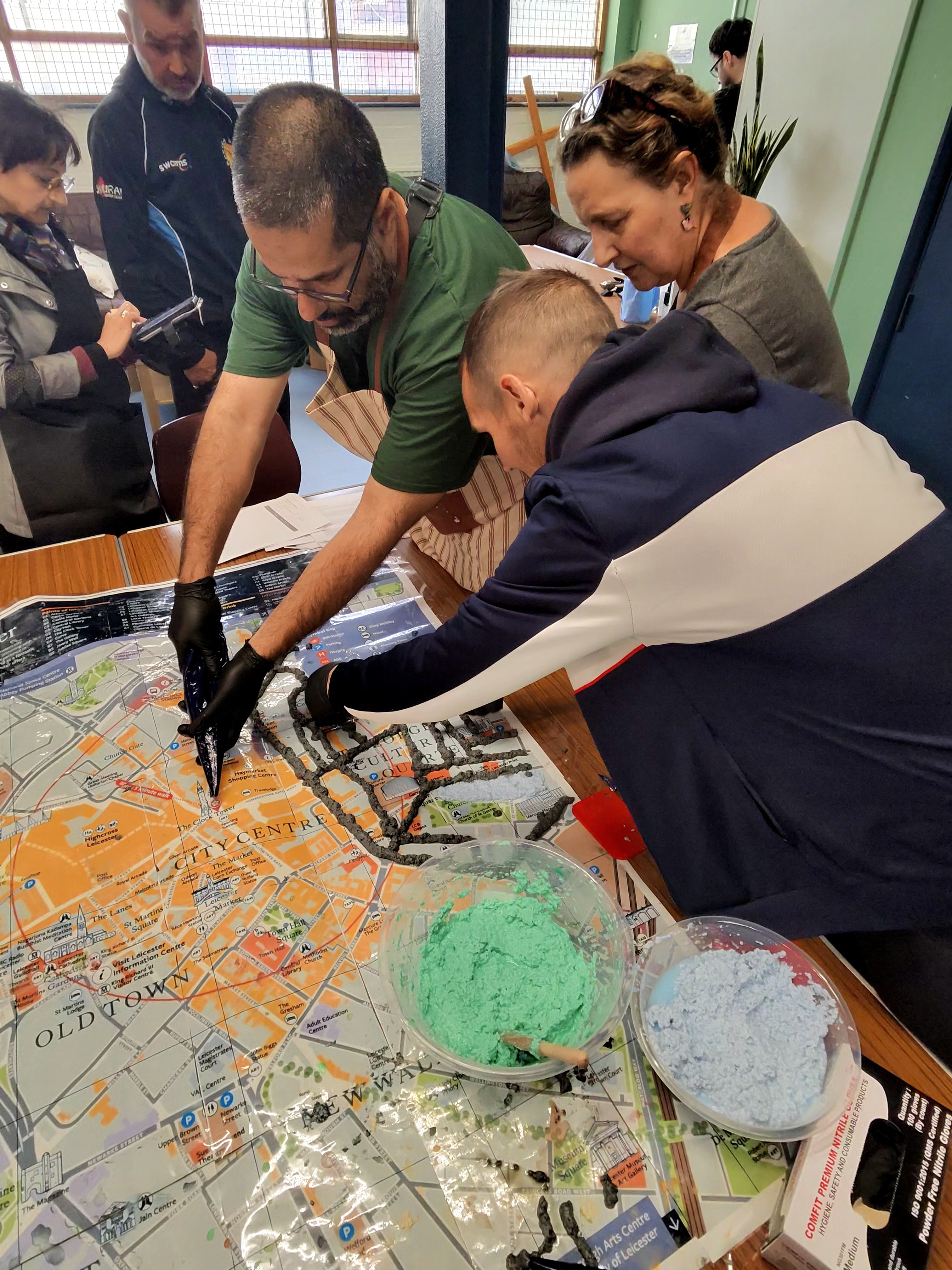 Participants at The Bridge mixing coloured pulp and laying it down on the Cultural Quarter section of the map.