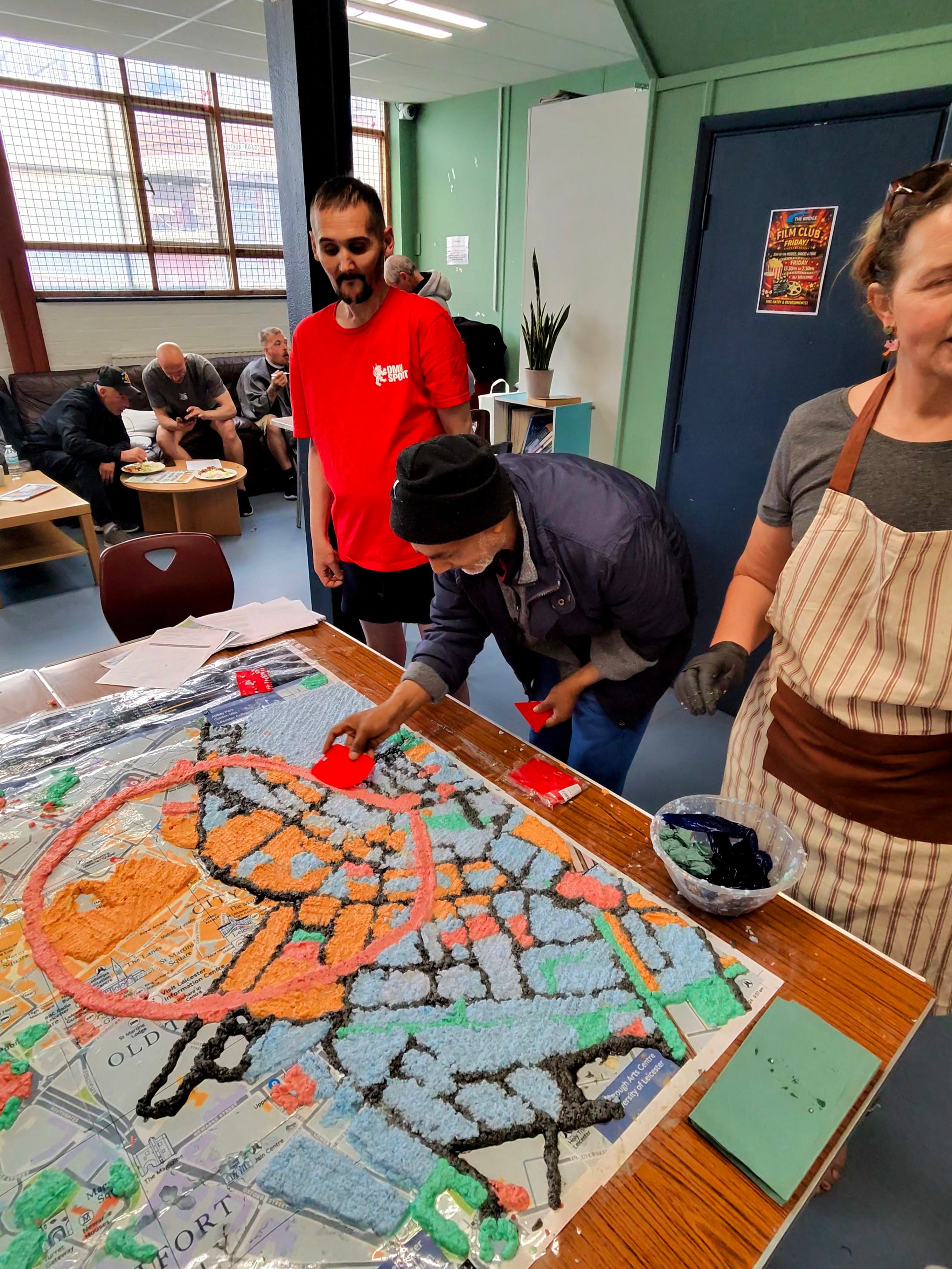 The map taking shape, in colour, with participants working around it.